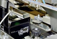 Maschinelle Verpackung der befüllten Einzeldosen  in entsprechende Verkaufskartons